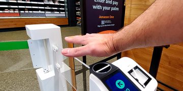 A shopper using Amazon One - norvanreports