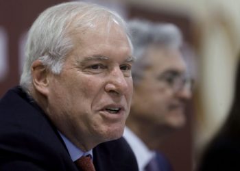 In this Nov. 25, 2019 file photo Federal Reserve Bank of Boston President Eric Rosengren, left, speaks during a round table discussion at Silver Lane Elementary School, in East Hartford, Conn.  (AP Photo/Steven Senne, file)