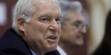 In this Nov. 25, 2019 file photo Federal Reserve Bank of Boston President Eric Rosengren, left, speaks during a round table discussion at Silver Lane Elementary School, in East Hartford, Conn.  (AP Photo/Steven Senne, file)