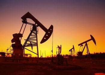 Oil field scene, the evening of beam pumping unit in silhouette