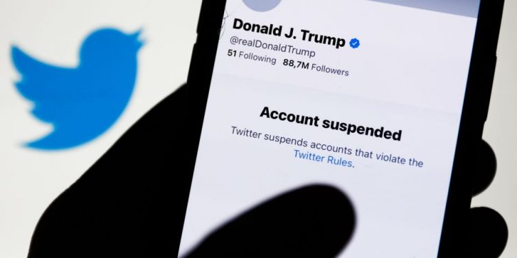 Donald Trump's Twitter account displayed on a phone screen and Twitter logo in the background are seen in this illustration photo taken in Poland on January 9, 2021. Twitter suspended Donald Trump's account because of violating the app rules. (Photo by Jakub Porzycki/NurPhoto via Getty Images)
