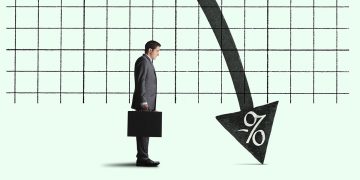 A businessman holding a briefcase stands somewhat disinterested by a chart indicating the concept of negative interest rates.