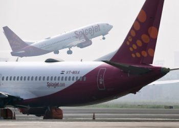 A SpiceJet aircraft takes off as another is pictured on the tarmac at Netaji Subhas Chandra Bose International Airport in Kolkata on October 17, 2019. (Photo by DIBYANGSHU SARKAR / AFP) (Photo by DIBYANGSHU SARKAR/AFP via Getty Images)
