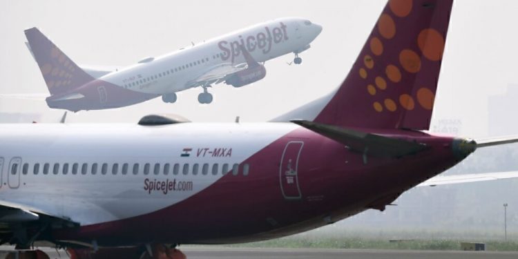 A SpiceJet aircraft takes off as another is pictured on the tarmac at Netaji Subhas Chandra Bose International Airport in Kolkata on October 17, 2019. (Photo by DIBYANGSHU SARKAR / AFP) (Photo by DIBYANGSHU SARKAR/AFP via Getty Images)