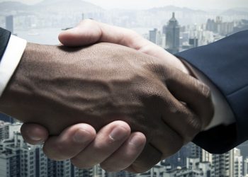 Businessmen shaking hands with cityscape in the background