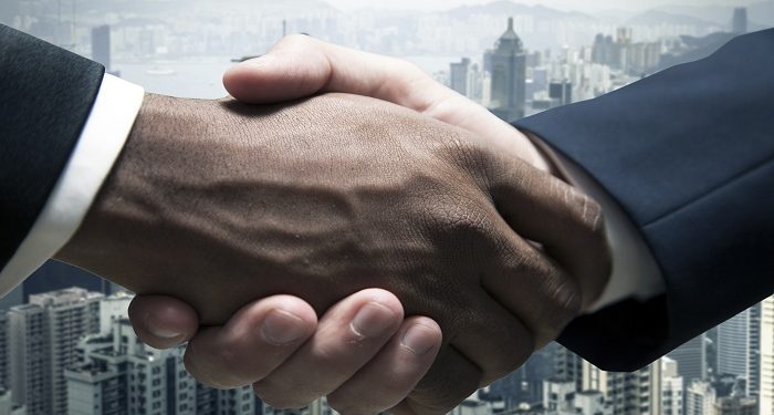 Businessmen shaking hands with cityscape in the background