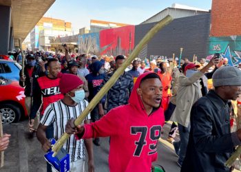 Stick-wielding protesters march through the streets as violence following the jailing of former South African President Jacob Zuma spread to the country's main economic hub in Johannesburg, South Africa, July 11, 2021. REUTERS/ Siphiwe Sibeko