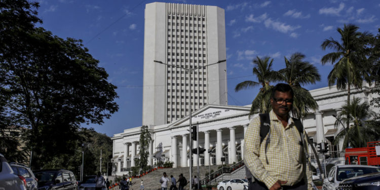 A pedestrian walks past the Reseve Bank of India (RBI) in Mumbai, India, on Monday, March. 9, 2020. A top Indian official said there's no need for the government to take immediate steps to support the economy following a crash in oil prices that has sent financial markets into a tailspin. Photographer: Dhiraj Singh/Bloomberg via Getty Images