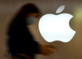 A woman walks past an Apple logo in front of an Apple store in Saint-Herblain near Nantes, France, September 16, 2021. REUTERS/Stephane Mahe