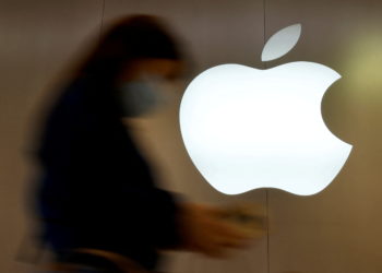 A woman walks past an Apple logo in front of an Apple store in Saint-Herblain near Nantes, France, September 16, 2021.  REUTERS/Stephane Mahe