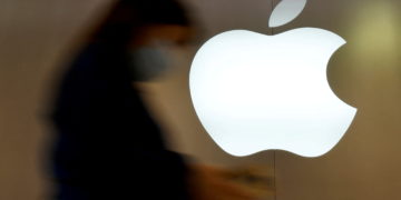 A woman walks past an Apple logo in front of an Apple store in Saint-Herblain near Nantes, France, September 16, 2021.  REUTERS/Stephane Mahe