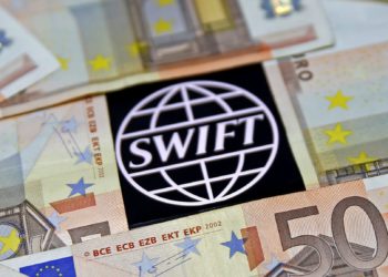 FILE PHOTO: Swift code bank logo is displayed on an iPhone 6s among Euro banknotes in this picture illustration January 26, 2016.  REUTERS/Dado Ruvic/File Photo
