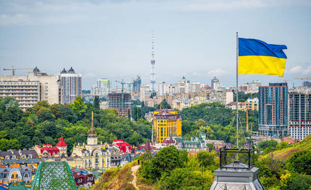 Kyiv, Ukraine cityscape of Kiev and Ukrainian flag waving in the wind during summer in Podil district and colorful new buildings