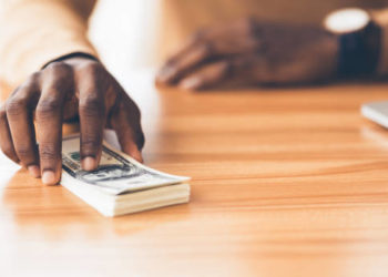 Venality Concept. Unrecognizable african businessman holding bunch of hundred dollar bills, copy space, panorama