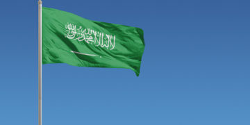 Flag of Saudi Arabia in front of a clear blue sky
