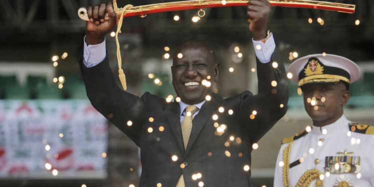 Kenya's new president William Ruto, seen behind fountain fireworks, holds up a ceremonial sword as he is sworn in to office at a ceremony held at Kasarani stadium in Nairobi, Kenya Tuesday, Sept. 13, 2022. William Ruto was sworn in as Kenya's president on Tuesday after narrowly winning the Aug. 9 election and after the Supreme Court last week rejected a challenge to the official results by losing candidate Raila Odinga. (AP Photo/Brian Inganga)