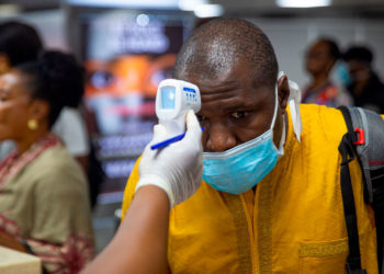 A passenger's body temperature is being tested at the gate of entry upon arrival at the Murtala International Airport in Lagos, on March 2, 2020. - Nigeria is monitoring 58 people who had contact with an Italian man infected with the new coronavirus, the health minister said Monday, as officials scrambled to stop the disease spreading. Africa's most populous country on Friday confirmed the first case of the virus in sub-Saharan Africa after the patient was diagnosed in the economic hub Lagos. (Photo by BENSON IBEABUCHI / AFP) (Photo by BENSON IBEABUCHI/AFP via Getty Images)