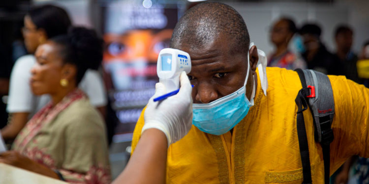 A passenger's body temperature is being tested at the gate of entry upon arrival at the Murtala International Airport in Lagos, on March 2, 2020. - Nigeria is monitoring 58 people who had contact with an Italian man infected with the new coronavirus, the health minister said Monday, as officials scrambled to stop the disease spreading. Africa's most populous country on Friday confirmed the first case of the virus in sub-Saharan Africa after the patient was diagnosed in the economic hub Lagos. (Photo by BENSON IBEABUCHI / AFP) (Photo by BENSON IBEABUCHI/AFP via Getty Images)