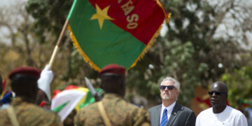 Minister of Defense and Veteran affairs, Chèrif Sy, U.S. Ambassador to Burkina Faso, Andrew Young, render honors during a pass and review portion of the closing ceremony to Flintlock 2019.  This year’s exercise is being hosted by U.S. African partner nation Burkina Faso.  By bringing members of the G5 Sahel, Multinational Joint Task Force, and various troop contributing nations together to develop and implement complimentary tactical operations, Flintlock 2019 better enables African partners to conduct real world missions structured around a coherent campaign plan. (U.S. Navy photo by MC2 (SW/AW) Evan Parker / released)