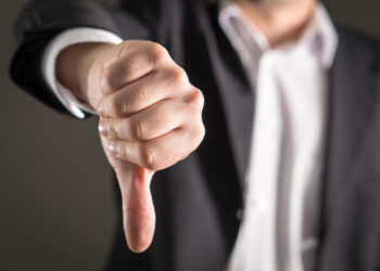 Businessman showing thumbs down.