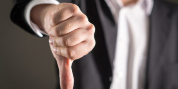 Businessman showing thumbs down.