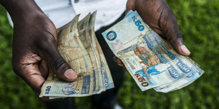 A man counts out Zambian kwacha 50 denomination banknotes in this arranged photograph in Lusaka, Zambia, on Thursday, Oct. 8, 2015. Zambian Finance Minister Alexander Chikwanda is seeking to restore confidence in the economy to help reverse the world's worst currency performance, record borrowing costs and sliding growth. Photographer: Waldo Swiegers/Bloomberg
