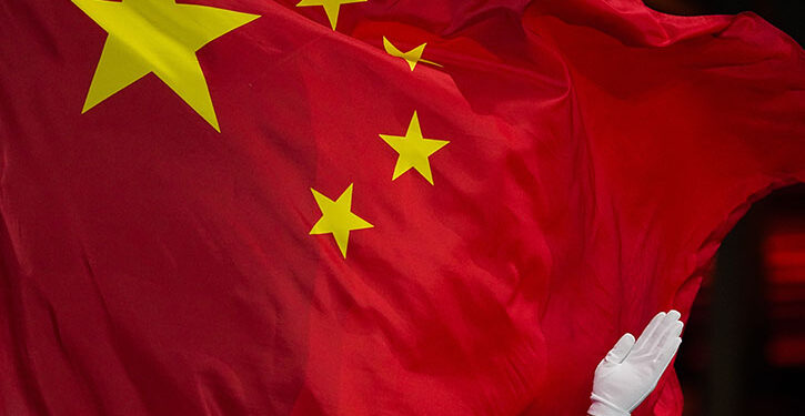 A Chinese flag is raised during a medal ceremony for the women's freestyle skiing big air at the 2022 Winter Olympics, Tuesday, Feb. 8, 2022, in Beijing. (AP Photo/Jae C. Hong)
