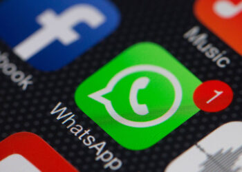 The WhatsApp Inc. mobile-messaging application WhatsApp and the Facebook Inc. application are displayed along with other apps on an Apple Inc. iPhone in this arranged photograph taken in Hong Kong, China, on Thursday, Feb. 20, 2014. Facebook, the worlds largest social network, agreed to acquire mobile-messaging startup WhatsApp Inc. for as much as $19 billion in cash and stock, seeking to expand its reach among users on mobile devices. Photographer: Bloomberg/Bloomberg