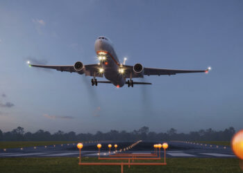 Airplane taking off from the airport runway at night. 3d rendering of a commercial flight taking off from an illuminated airstrip