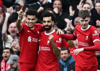Liverpool's Egyptian striker #11 Mohamed Salah (C) celebrates after scoring his team second goal during the English Premier League football match between Liverpool and Brighton and Hove Albion at Anfield in Liverpool, north west England on March 31, 2024. (Photo by Paul ELLIS / AFP) / RESTRICTED TO EDITORIAL USE. No use with unauthorized audio, video, data, fixture lists, club/league logos or 'live' services. Online in-match use limited to 120 images. An additional 40 images may be used in extra time. No video emulation. Social media in-match use limited to 120 images. An additional 40 images may be used in extra time. No use in betting publications, games or single club/league/player publications. / (Photo by PAUL ELLIS/AFP via Getty Images)