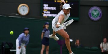 Poland's Iga Swiatek misses a return against Kazakhstan's Yulia Putintseva during their women's singles tennis match on the sixth day of the 2024 Wimbledon Championships at The All England Lawn Tennis and Croquet Club in Wimbledon, southwest London, on July 6, 2024. Putintseva won the third round match 3-6, 6-1, 6-2. (Photo by HENRY NICHOLLS / AFP) / RESTRICTED TO EDITORIAL USE